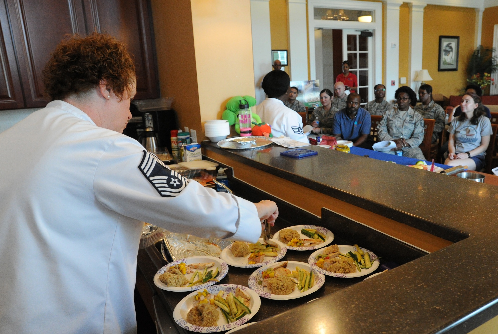 Chief Master Sgt. Laura Kelly, Air Force Enlisted Aide plates meals cooked during the Healthy Cooking Made Easy demonstration at Liberty Park Welcome Center on Joint Base Andrews, Md., June 25, 2015. (U.S. Air Force photo/ Staff Sgt. Nichelle Anderson)