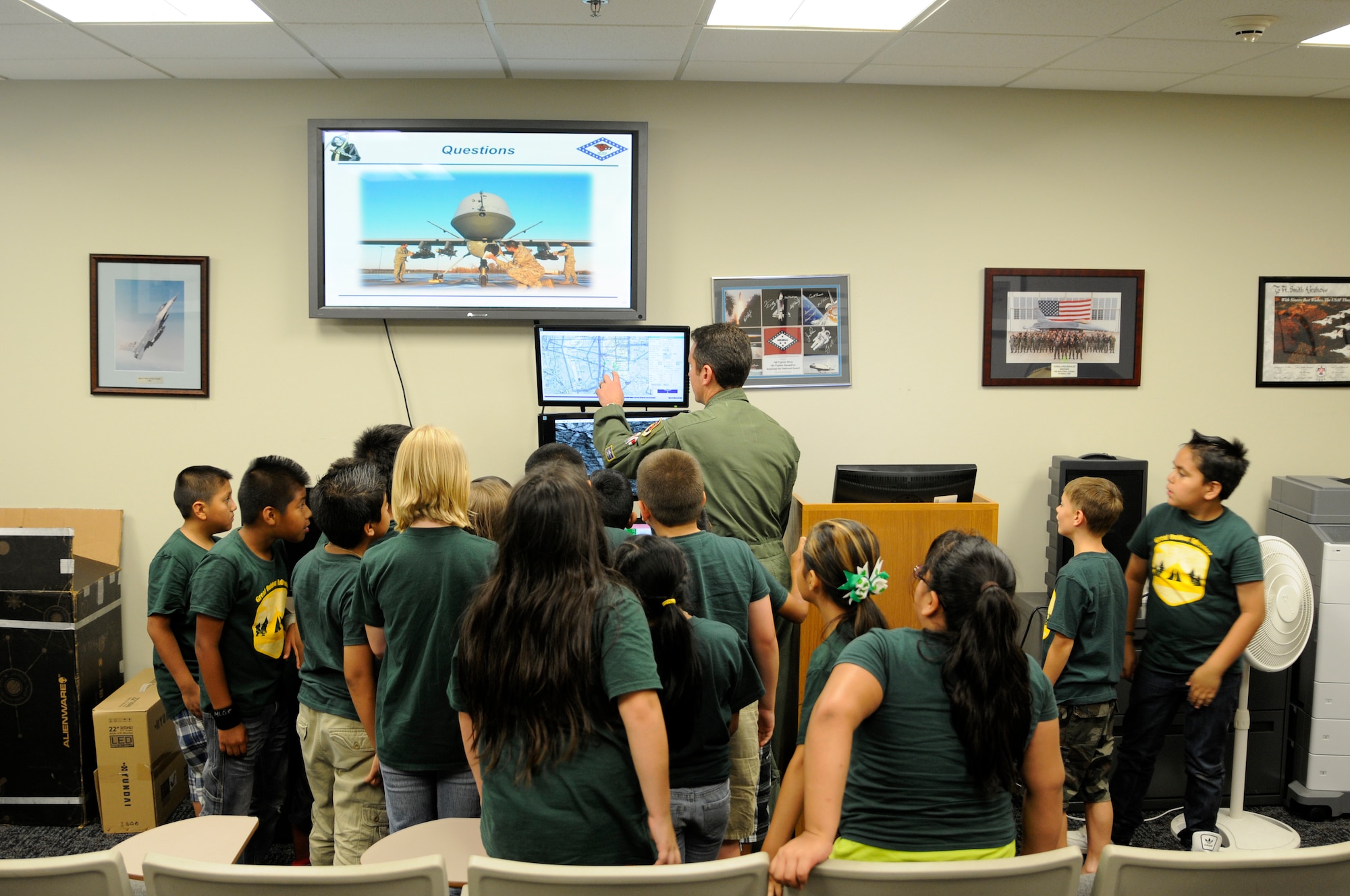 A pilot with the 184th Attack Squadron demonstrates the capabilities of the MQ-9 “Reaper” simulator to students from the Choctaw Nation in Leflore County, Okla., during a base tour at Ebbing Air National Guard Base, Ark. June 25, 2015. Students were able to see how Airmen at the 188th will impact operations overseas and learned how the aircraft can assist in domestic operations.  The MQ-9 is a remotely piloted aircraft the 188th Wing converted to with the mission change in 2014. (U.S. Air National Guard photo by Staff Sgt. Hannah Dickerson/Released)