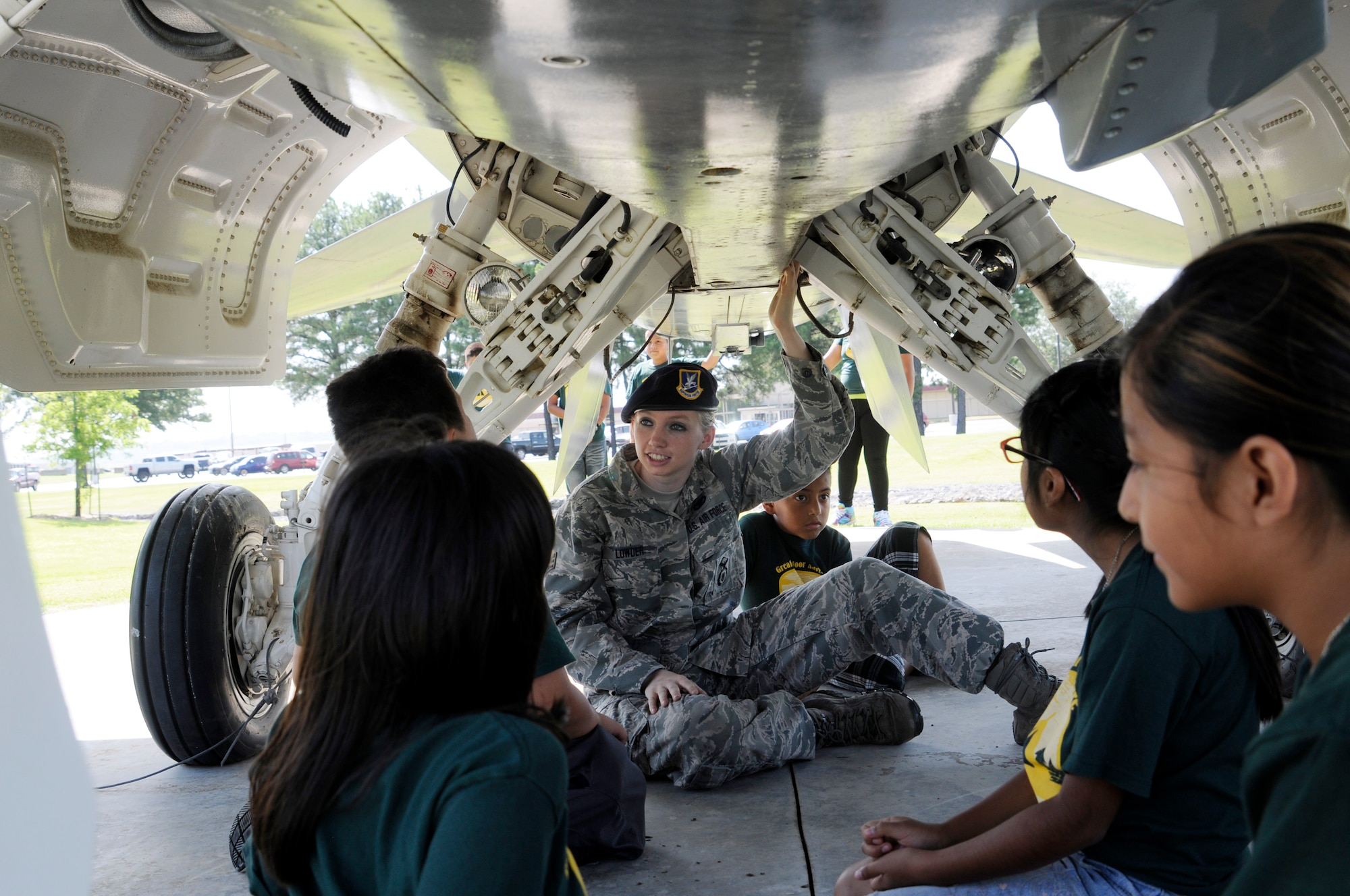 Senior Airmen Kylie Lowder, 188th Security Forces specialist, speaks to Choctaw Nation students during a base tour at Ebbing Air National Guard Base, Ark., June 25, 2015. Lowder explained her role as a defender in being the first line of defense in keeping Airmen and aircraft safe from any threats trying to gain access to the base. (U.S. Air National Guard photo by Staff Sgt. Hannah Dickerson/Released)