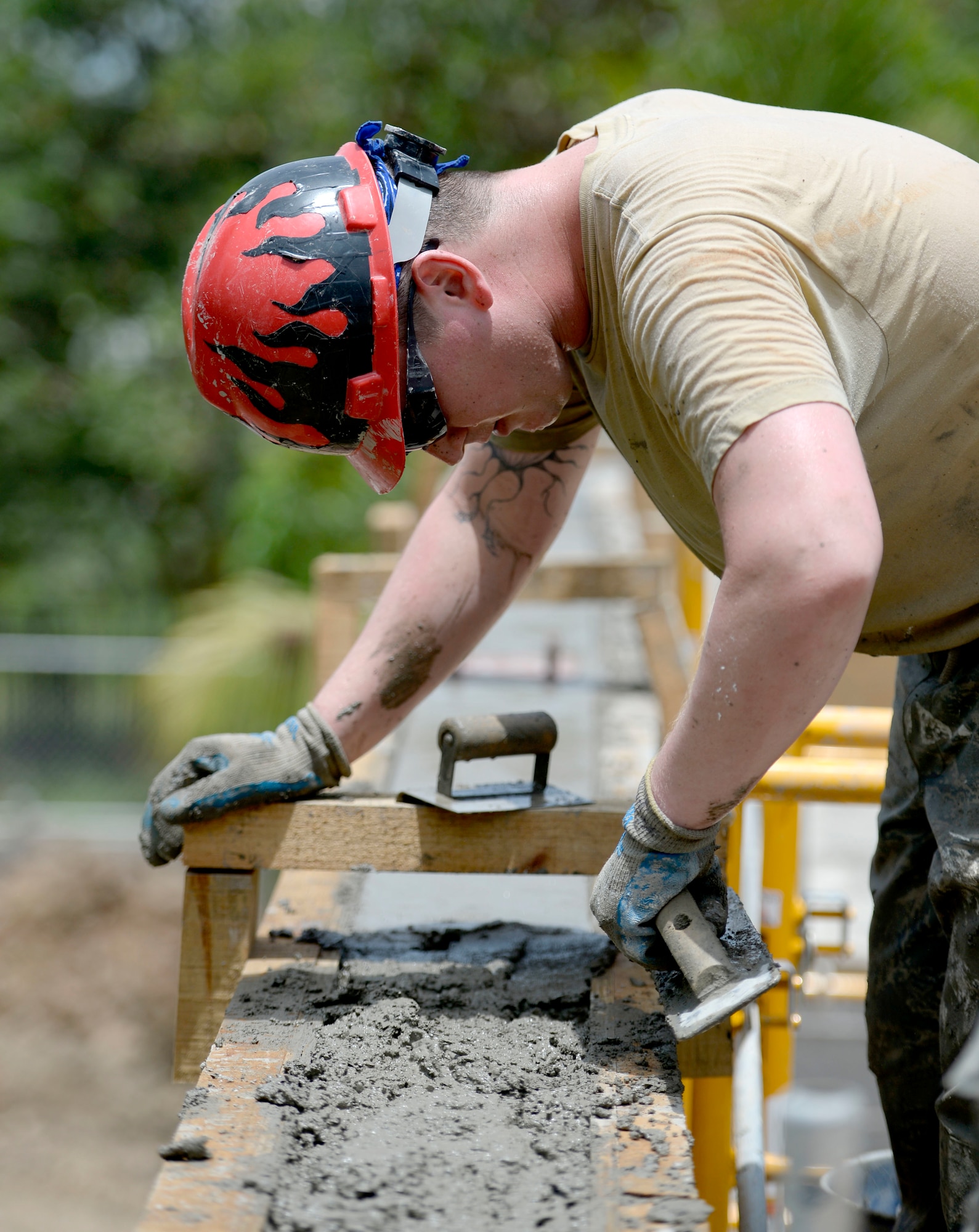 U.S. Air Force Senior Airman Dylan Troiani, 823rd Expeditionary RED HORSE Squadron structural journeyman, out of Hurlburt Field, Fla., works to smooth out the cement used to create the bond beam at the top of new two-room school building at the Gabriela Mistral primary school construction site in Ocotes Alto, Honduras, June 22, 2015. The construction project is part of the NEW HORIZONS Honduras 2015 training exercise, an annual humanitarian exercise put on by U.S. Southern Command. NEW HORIZONS was launched in the 1980s and is an annual joint humanitarian assistance exercise that U.S. Southern Command conducts with a partner nation in Central America, South America or the Caribbean. The exercise improves joint training readiness of U.S. and partner nation civil engineers, medical professionals and support personnel through humanitarian assistance activities. (U.S. Air Force photo by Capt. David J. Murphy/Released)