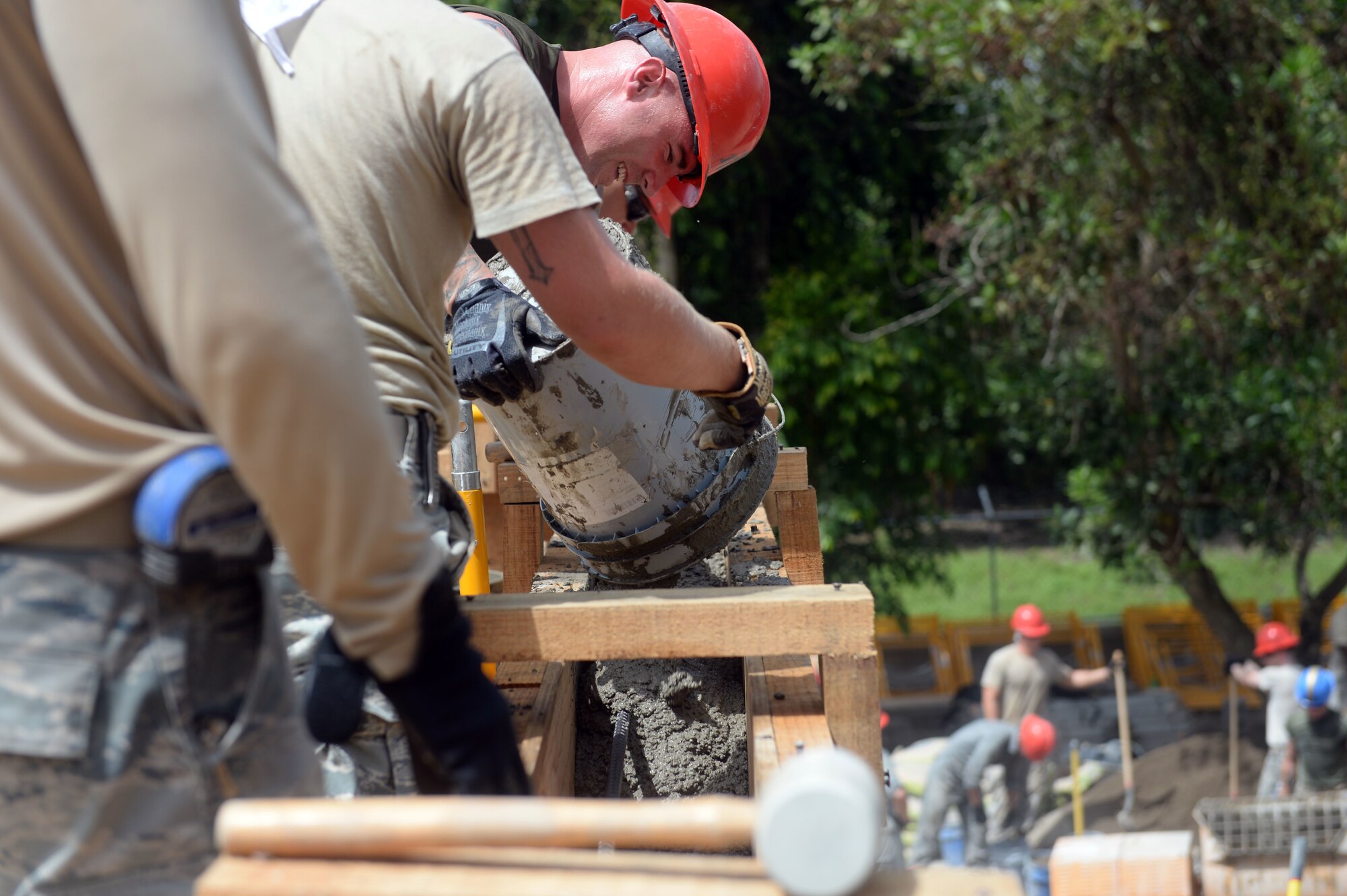 U.S. Marine Staff Sgt. Andrew Smith, a combat engineer with a 271st Marine Wing Support Squadron, 2nd Marine Air Wing, pours cement into a wood frame to create a bond beam for the new two-room schoolhouse at the Gabriela Mistral school construction site in Ocotes Alto, Honduras, June 22, 2015. The school project is one part of the NEW HORIZONS Honduras 2015, an annual humanitarian and training exercise put on by U.S. Southern Command. NEW HORIZONS was launched in the 1980s and is an annual joint humanitarian assistance exercise that U.S. Southern Command conducts with a partner nation in Central America, South America or the Caribbean. The exercise improves joint training readiness of U.S. and partner nation civil engineers, medical professionals and support personnel through humanitarian assistance activities. (U.S. Air Force photo by Capt. David J. Murphy/Released)