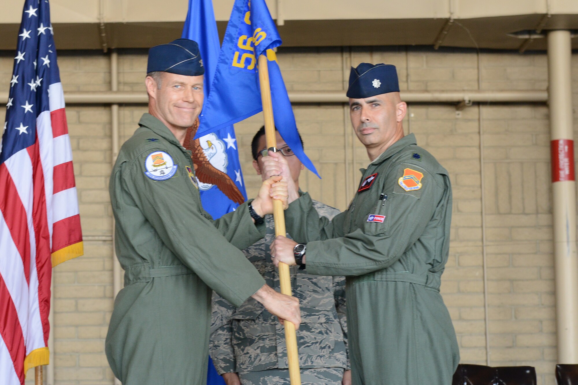 Col. William Bailey, 56th Operations Group commander, passes the 21st Fighter Squadron guidon to Lt. Col. Javier Antuna, incoming commander, June 19 at Luke Air Force Base.