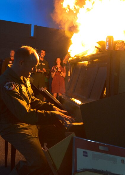 Lt. Col. Christopher Bacon, 308th Fighter Squadron commander, plays the burning piano during the 308th FS inactivation party June 12 at Luke Air Force Base (U.S. Air Force photo by SrA Devante Williams)