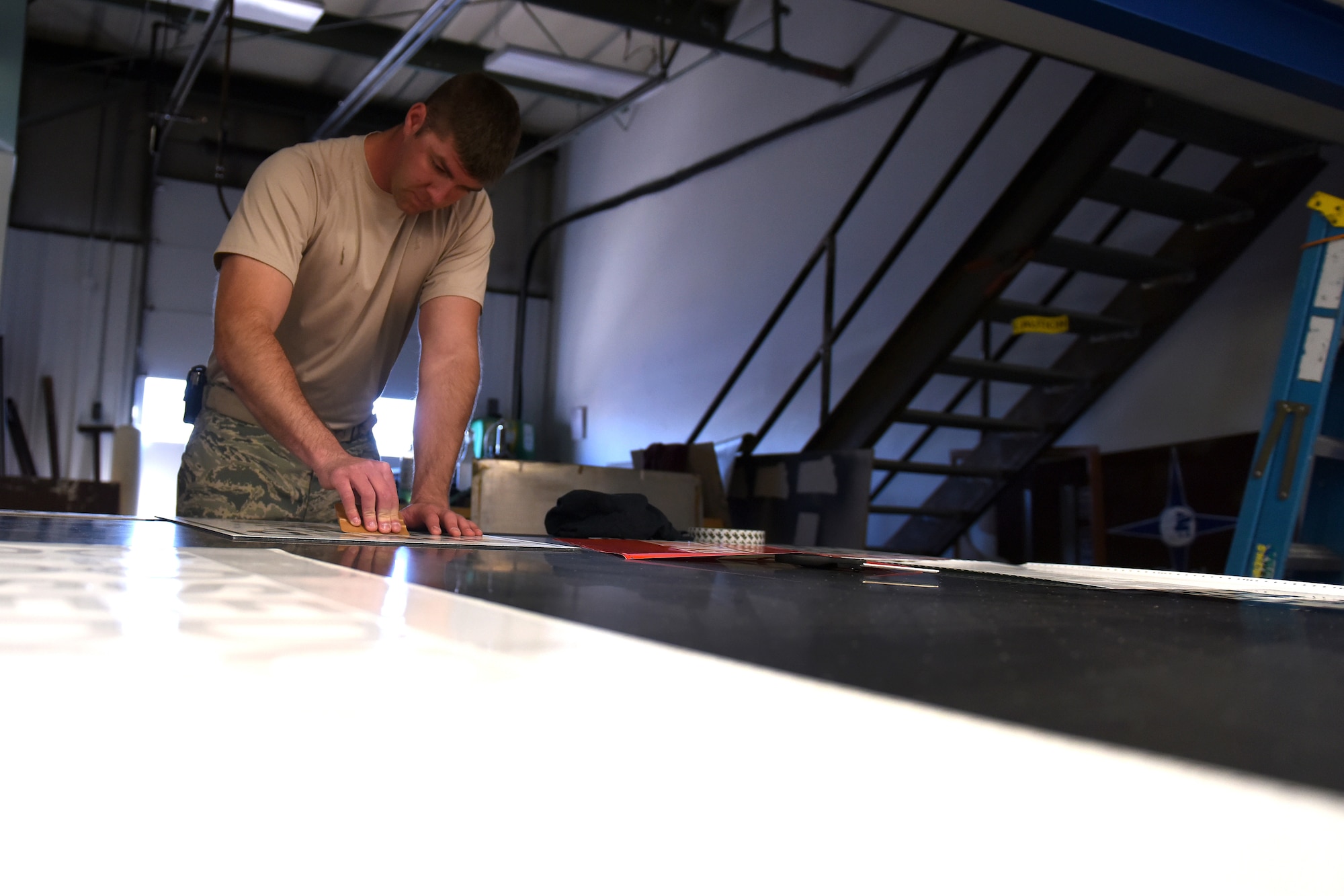 Staff Sgt. Jacob Richey, 341st Civil Engineer Squadron carpenter shop NCO in charge, prepares a new base sign June 26, 2015, at Malmstrom Air Force Base, Mont. The shop has personnel made up of civilian and active duty, and encompass four sub-sections: carpentry, metal, locksmith and sign shop. (U.S. Air Force photo/Chris Willis)
