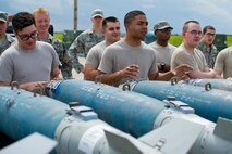 Airmen from Airman Leadership Class 15-Echo observe the finished, inert GBU-38 after being assembled by Airmen from the 5th Munitions Squadron at Minot Air Force Base, N.D., June 25, 2015. Airman Leadership Class 15-Echo observed the build to better understand 5 MUNS operations and to help prepare the build team to working in front of an audience for the 2015 Global Strike Challenge. (U.S. Air Force photo/Airman 1st Class Justin T. Armstrong)