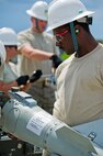 Senior Airman Davarren Hamilton, a 5th Munitions Squadron munitions custody account technician, holds a KMU-572 tail section of an inert GBU-38 at Minot Air Force Base, N.D., June 25, 2015.  Hamilton, along with his team, will be participating in the 5th annual Global Strike Command Global Strike Challenge at Barksdale AFB, L.A. (U.S. Air Force photo/Airman 1st Class Justin T. Armstrong)