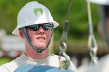Senior Airman Roddy Looper, a 5th Munitions Squadron conventional maintenance crew member, hoists inert GBU-38s as the first step in the process of assembling the munitions at Minot Air Force Base, N.D., June 25, 2015. The 5 MUNS team trains for the annual Global Strike Challenge held at Barksdale AFB, L.A. (U.S. Air Force photo/Airman 1st Class Justin T. Armstrong)