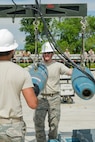 Senior Airman Roddy Looper, a 5th Munitions Squadron conventional maintenance crew member, hoists inert GBU-38 munitions to be assembled at Minot Air Force Base, N.D, June 25, 2015. Airman Leadership Class 15-Echo attended the build to observe operations and to help the 5 MUNS team adjust to working in front of an audience for the upcoming Global Strike Challenge. (U.S. Air Force photo/Airman 1st Class Justin T. Armstrong)