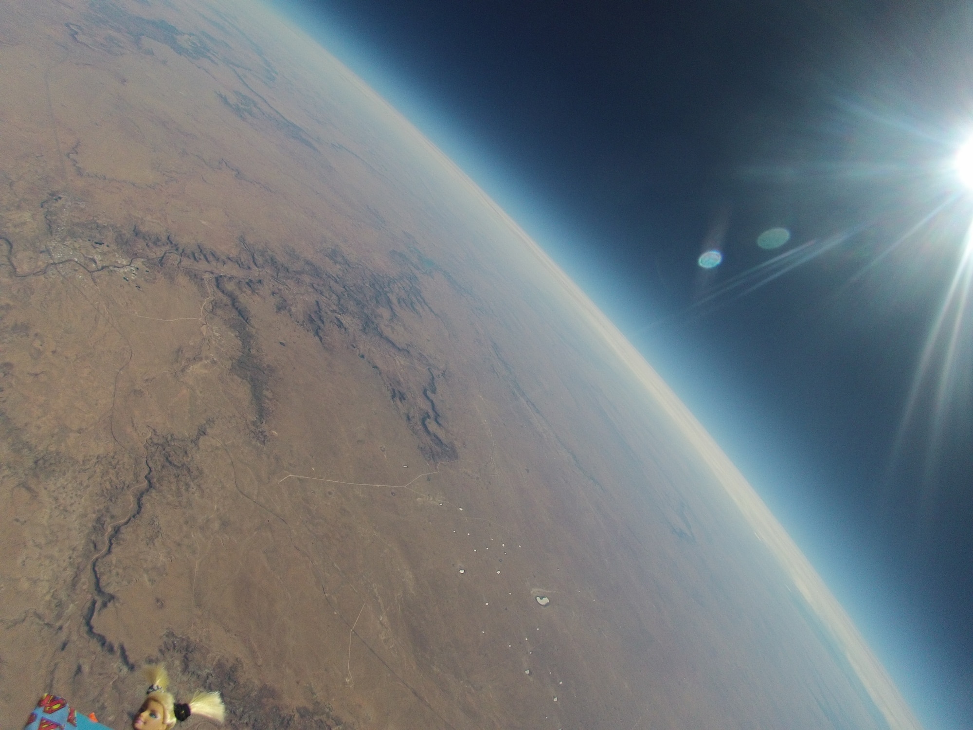 An image of the earth taken by the high-altitude helium balloon launched recently by Albuquerque Public School District and Valley High School’s AF JROTC unit. The cadets sent a doll, lower left, along for the ride. (Contributed/Cleared)