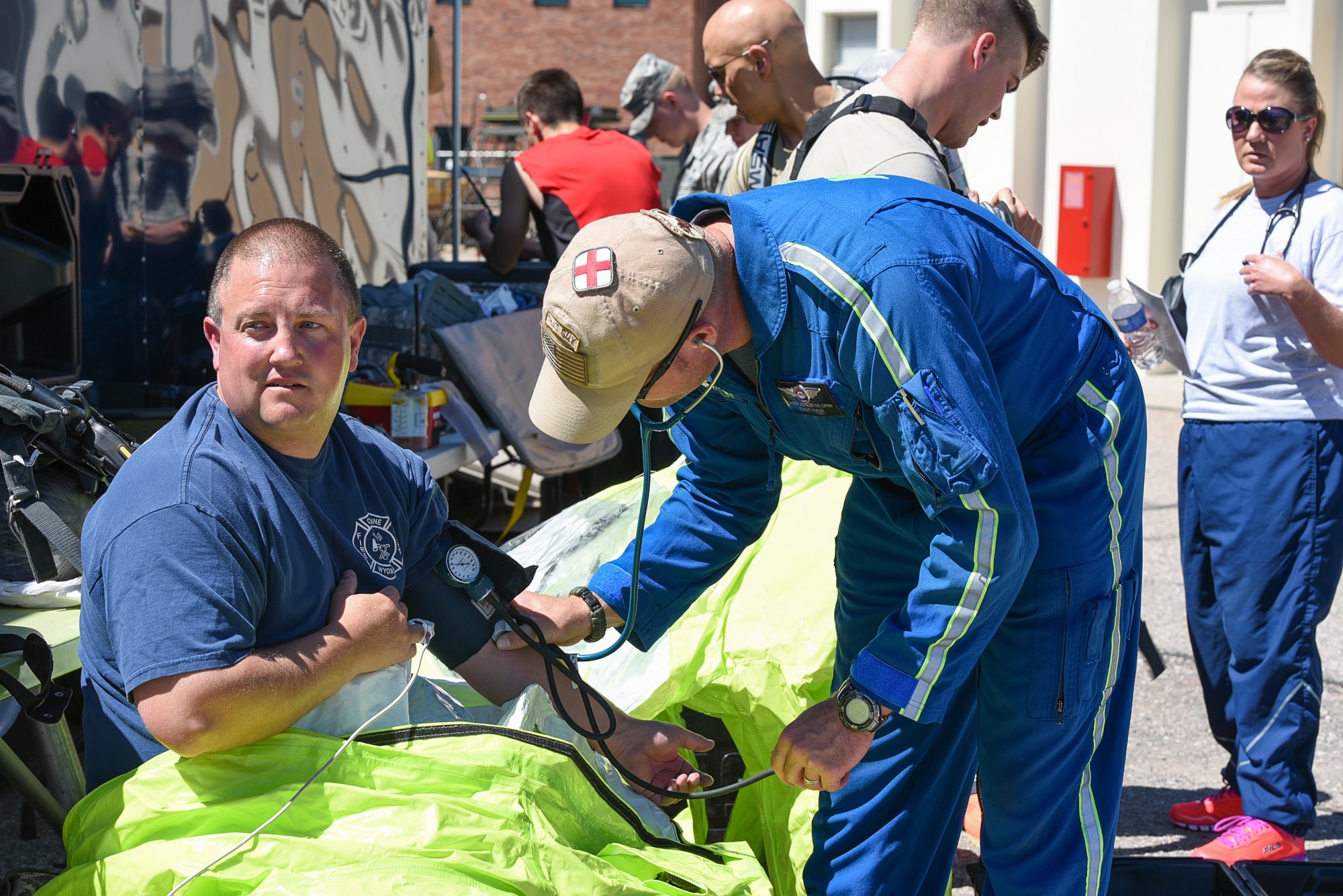 Casey Zeigler, AirLife Denver flight nurse, checks the vital signs of Region 7 Hazmat Engineer Brent Osborne, June 19, 2015, at Cheyenne Air National Guard Base in Cheyenne, Wyo. Civilian and military first responders are participating in Counter-CBRN All-Hazard Management Response (CAMR) training to practice chemical, biological, radiological, first response, medical, and incident command scenarios for possible threats in the region. (U.S. Air National Guard photo by Master Sgt. Charles Delano)
