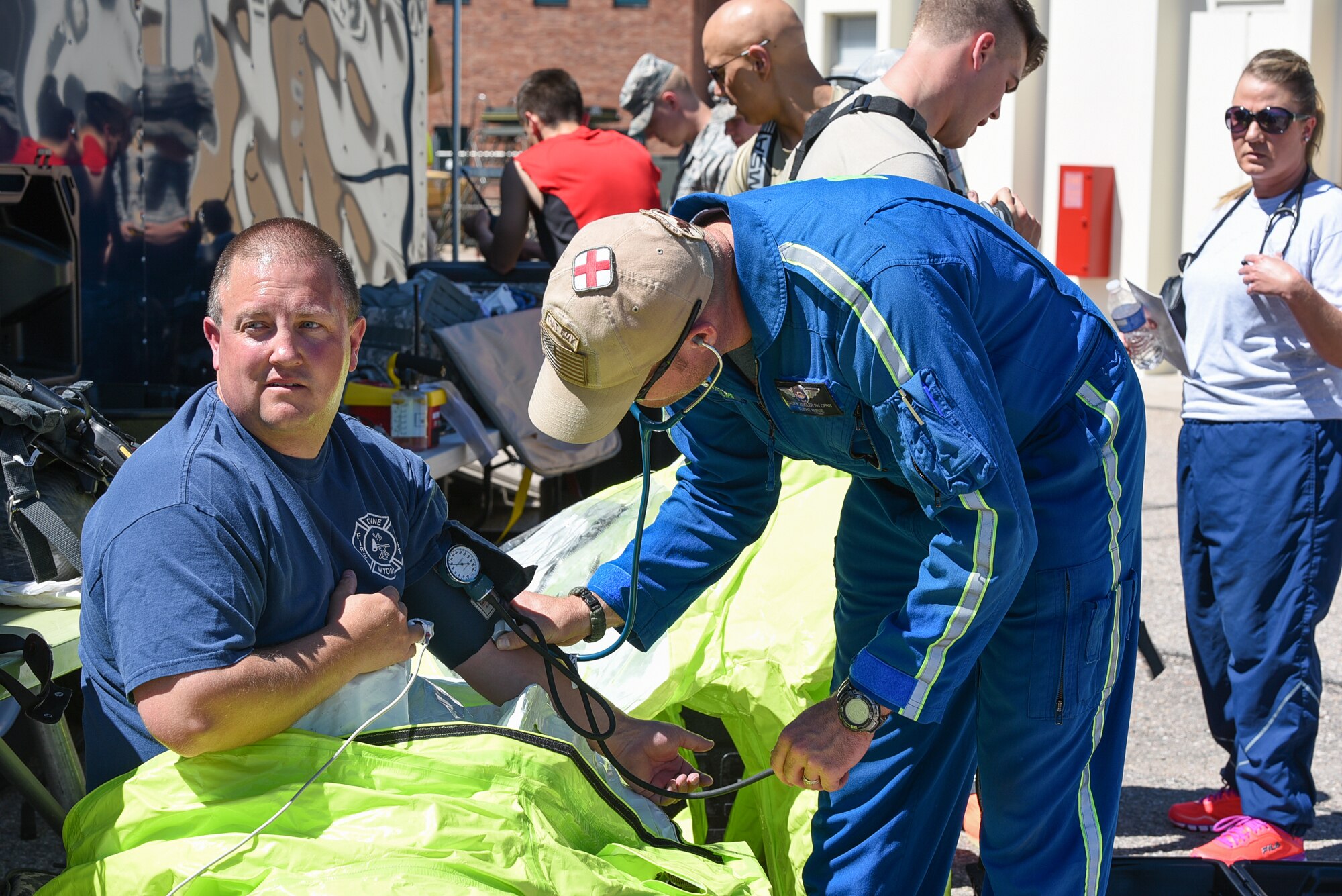 Casey Zeigler, AirLife Denver flight nurse, checks the vital signs of Region 7 Hazmat Engineer Brent Osborne, June 19, 2015, at Cheyenne Air National Guard Base in Cheyenne, Wyo. Civilian and military first responders are participating in Counter-CBRN All-Hazard Management Response (CAMR) training to practice chemical, biological, radiological, first response, medical, and incident command scenarios for possible threats in the region. (U.S. Air National Guard photo by Master Sgt. Charles Delano)