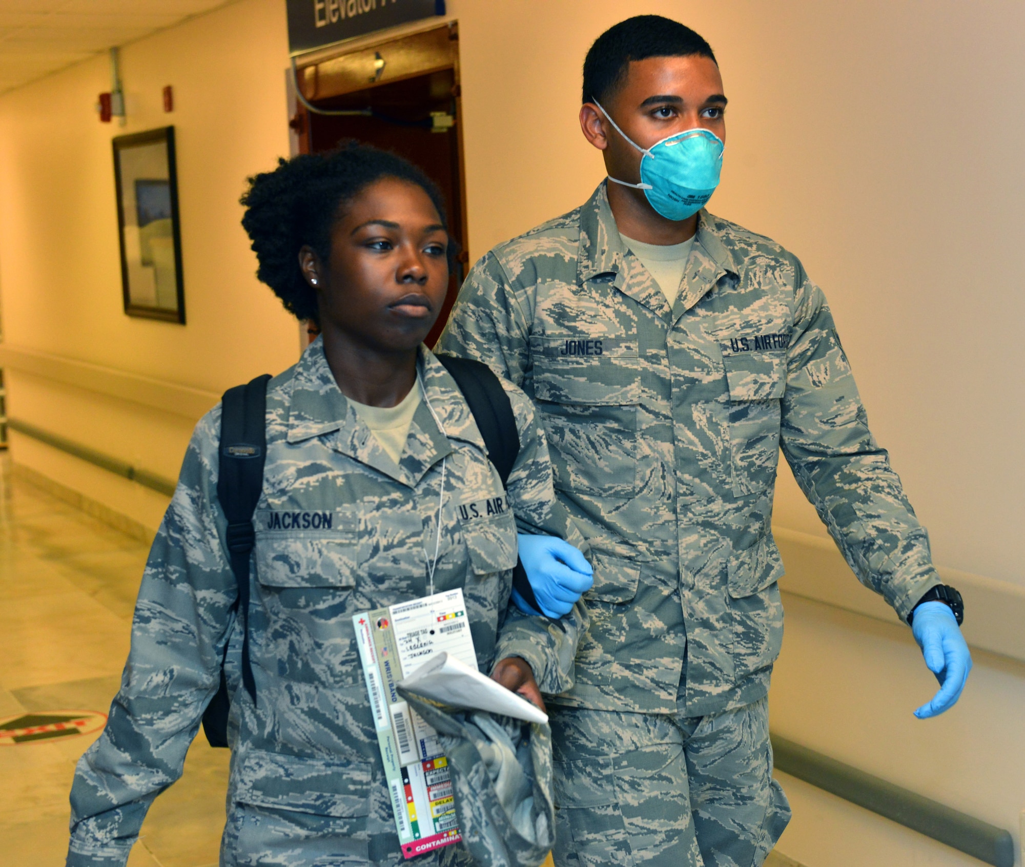 Airman 1st Class Xavier Jones, 39th Medical Operations Squadron public health technician, escorts Senior Airman Ladeania Jackson, 39th Logistics Readiness Squadron commander support section technician, to a medical holding room during a mass accident response exercise June 25, 2015, at Incirlik Air Base, Turkey.  During the exercise, agencies from across the base were tested on their ability to respond to a simulated aircraft crash. (U.S. Air Force photo by Senior Airman Michael Battles/Released)