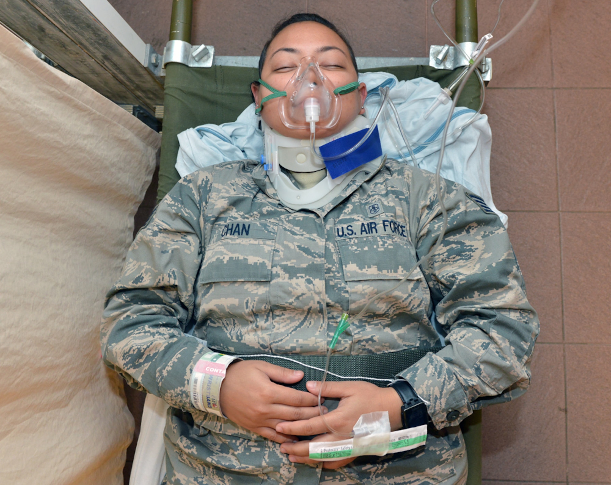 Staff Sgt. Aleza Chan, 39th Medical Support Squadron lab technician, lays on a medical bed during a mass accident response exercise June 25, 2015, at Incirlik Air Base, Turkey.  The exercise tested the response times of several base agencies including security forces, fire department, medical, explosive ordnance disposal and maintenance. (U.S. Air Force photo by Senior Airman Michael Battles/Released)