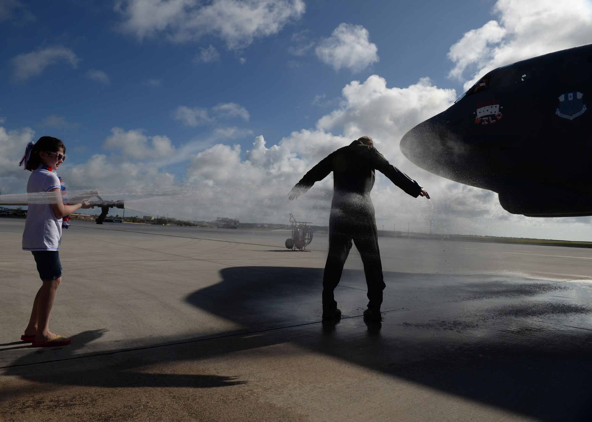 Col. Reid Langdon, 36th Operations Group commander, gets sprayed by his daughter following his fini-flight June 25, 2015, at Andersen Air Force Base, Guam. The fini-flight reception honors aviators’ careers and includes a celebratory toast and dowsing with water for the aircraft and aircrew. (U.S. Air Force photo by Senior Airman Alexander W. Riedel/Released)