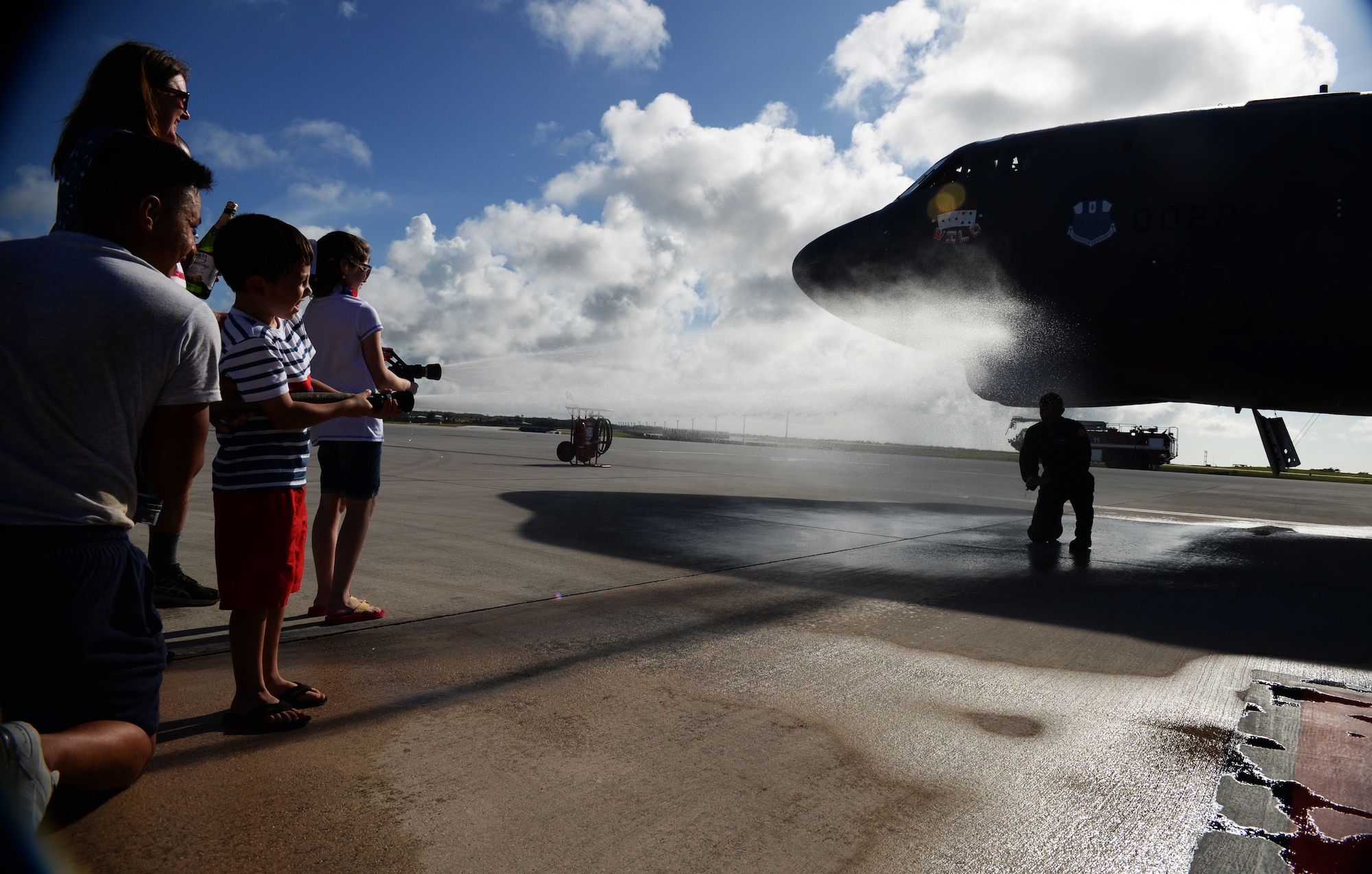 Col. Reid Langdon, 36th Operations Group commander, gets sprayed by his wife and children following his fini-flight June 25, 2015, at Andersen Air Force Base, Guam. The fini-flight reception honors aviators’ careers and includes a celebratory toast and dowsing with water for the aircraft and aircrew. (U.S. Air Force photo by Senior Airman Alexander W. Riedel/Released)