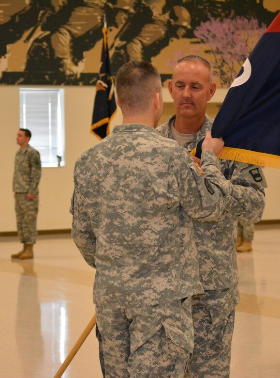 Command Sgt. Maj. Jeffry Darlington, acting senior noncommissioned officer 800th Logistics Support Brigade, (facing camera) passes the brigade colors to Col. Howard C. W. Geck, the outgoing commander during a change of command ceremony Mustang, Okla., June 28, 2015. Col. Bradly M. Boganowski replaced Geck as commander.