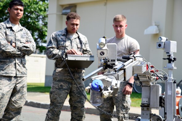 U.S. Air Force Staff Sgt. Brandon Elmore, 35th Aircraft Maintenance Squadron lead load crew member, uses an F-6A Robot to pick up a water bottle during a job swap at Misawa Air Base, Japan, June 23, 2015. This robot is a tool used by explosive ordnance disposal Airmen for remotely interrogating suspect packages, picking up munitions, and other operations. (U.S. Air Force photo by Airman 1st Class Jordyn Fetter/Released)