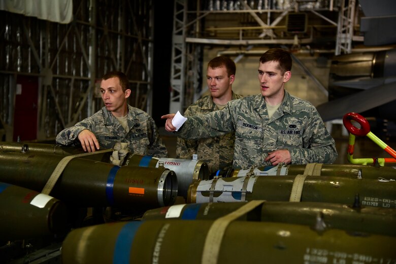 U.S. Air Force Senior Airman Robert Dickinson, 35th Aircraft Maintenance Squadron load crew member, explains the purposes of different aircraft munitions to 35th Civil Engineer Squadron explosive ordnance disposal Airmen during a job swap at Misawa Air Base, Japan, June 25, 2015. This job swap program is designed to show Airmen from a particular career field the inner workings and day-to-day mission of another Air Force job. (U.S. Air Force photo by Airman 1st Class Jordyn Fetter/Released)
