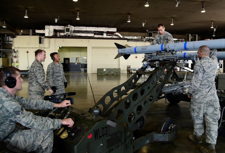 U.S. Air Force Senior Airman Travis Ditmanson, 35th Civil Engineer Squadron explosive ordnance disposal technician, connects a munition to an MJ-1 lift truck at Misawa Air Base, Japan, June 25, 2015. Ditmanson was able to play the role of a load crew member during a job swap between EOD and 35th Maintenance Group  load crew Airmen. (U.S. Air Force photo by Airman 1st Class Jordyn Fetter/Released)