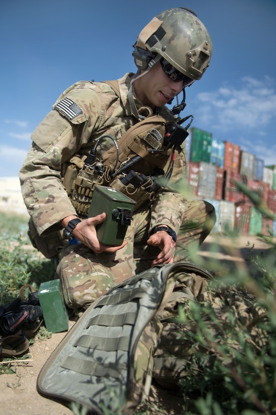 U.S. Air Force Senior Airman Grant Haefke changes the battery on his radio at an Afghan National Army combat outpost in Afghanistan, June 23, 2015.
