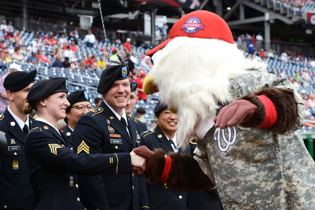 Screech, the mascot of the Washington Nationals baseball team, greets Army Sgt. Anna Ruhstorfer, left, during Army Day at Nationals Park in Washington, D.C., June 25, 2015. Ruhstorfer re-enlisted during the pregame military salute.