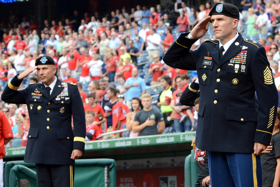 Army Lt. Gen. Joseph Anderson, left, and Sgt. Maj. of the Army Daniel A. Dailey render honors as the national anthem plays during Army Day events before a Washington Nationals-Atlanta Braves baseball game at Nationals Park in Washington, D.C., June 25, 2015.