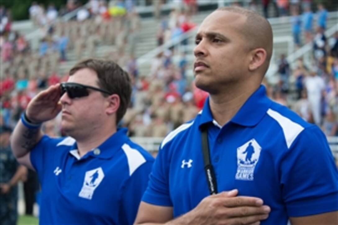Members of the U.S. Air Force team render honors during the playing of the national anthem at the 2015 Department of Defense Warrior Games closing ceremony on Marine Corps Base Quantico, Va., June 28, 2015.