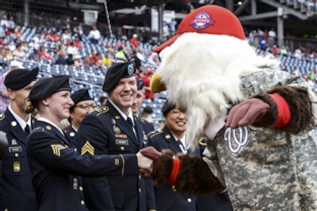 Screech, the mascot of the Washington Nationals baseball team, greets Army Sgt. Anna Ruhstorfer, left, during Army Day at Nationals Park in Washington, D.C., June 25, 2015. Ruhstorfer re-enlisted during the pregame military salute. The  pregame military salute also included a re-enlistment ceremony, soldier cordon, color guard presentation and performance by the Fife and Drum Corps. 