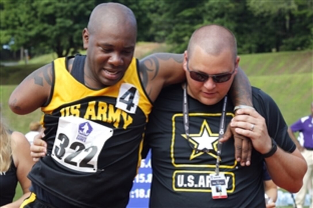 Army Sgt. 1st Class Michael Smith, left, walks of the track after finishing his race with the help of Army staff member Paul Trujillo during the 2015 Department of Defense Warrior Games on Marine Corps Base Quantico, Va., June 28, 2015. 