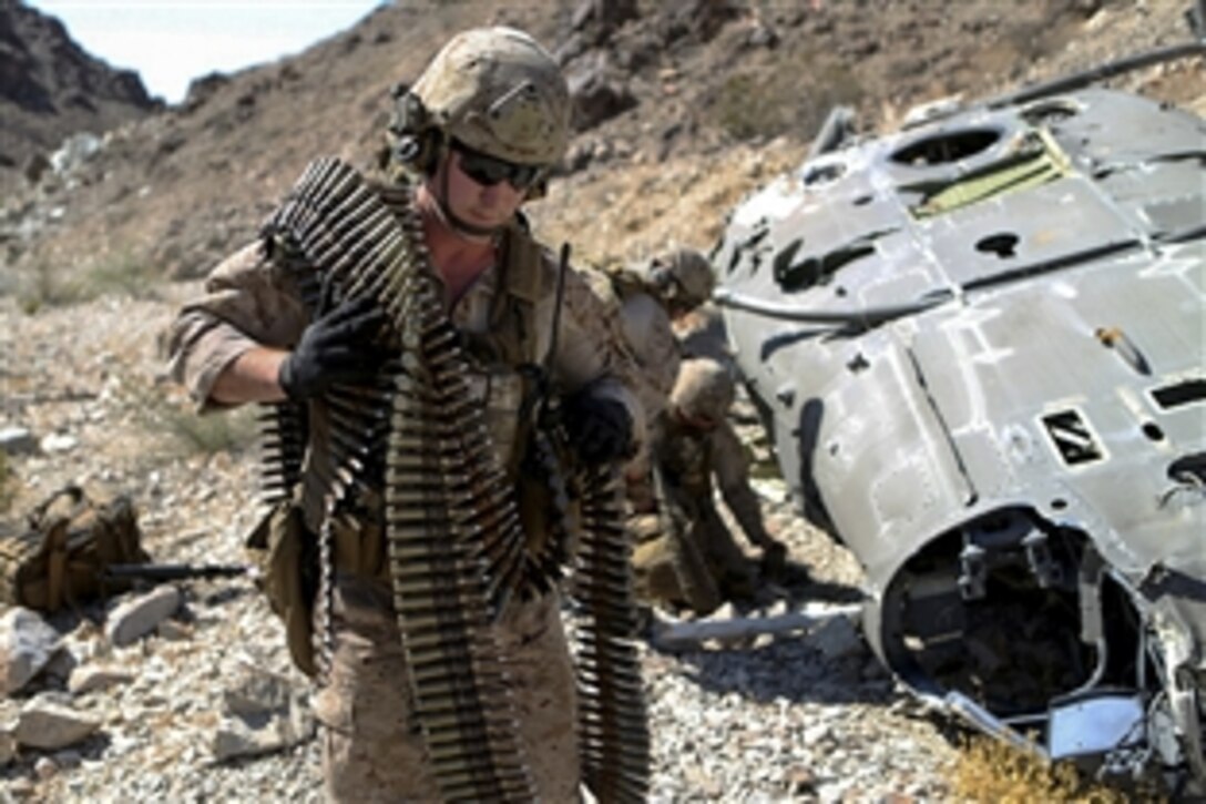 Marines remove ordnance from a simulated downed UH-1 Huey helicopter during a training exercise on Marine Corps Air Ground Combat Center Twentynine Palms, Calif., June 17, 2015. The Marines are assigned to the 1st Explosive Ordnance Disposal Company, 1st Marine Logistics Group.