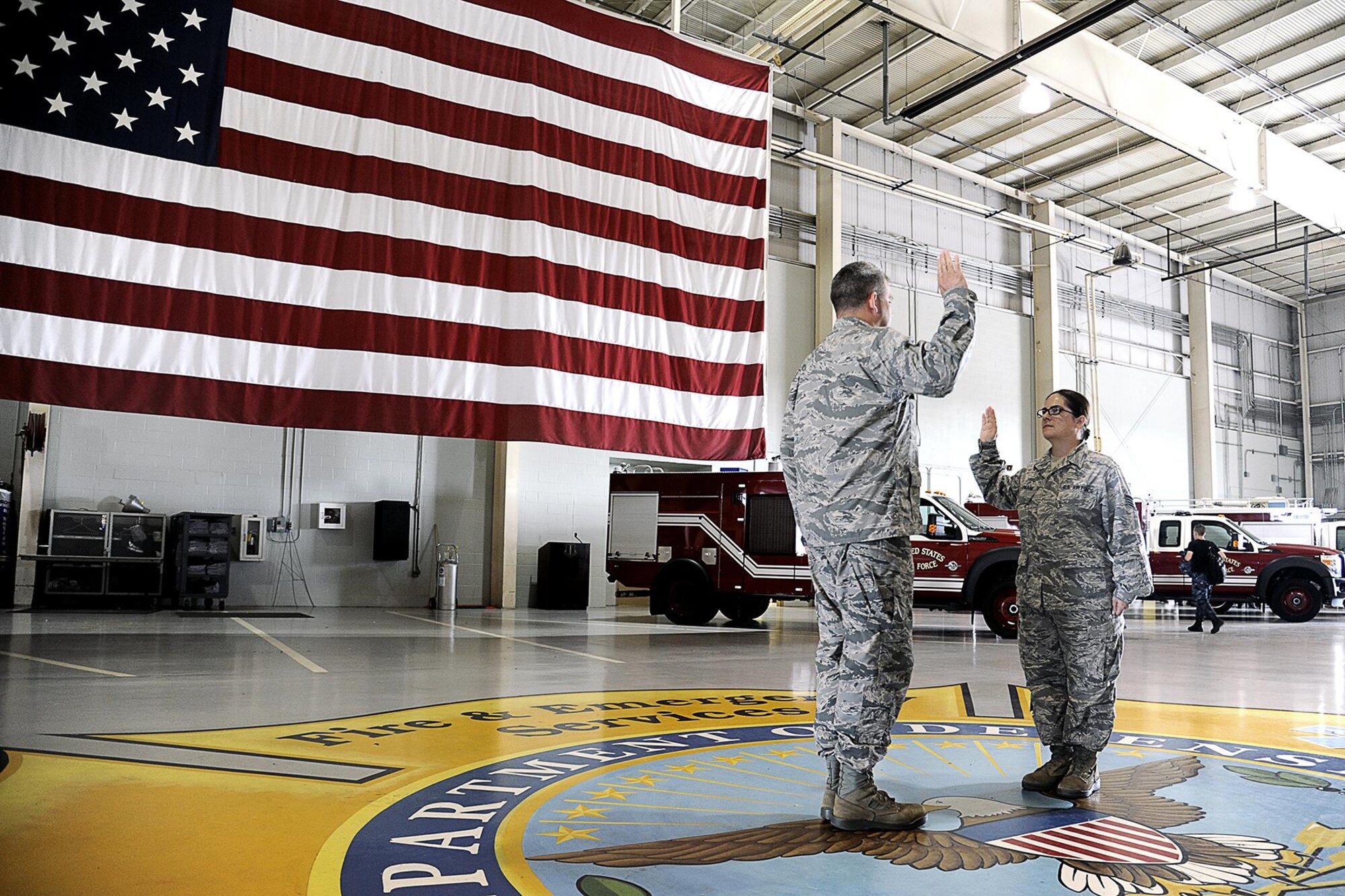 U.S. Air Force Lt. Col. Derek Ferland, 312th Training Squadron Commander, reenlists Staff Sgt. Laura R. McFarlane, 17th Training Wing Public Affairs photojournalist craftsman, at the Louis F. Garland Department of Defense Fire Academy on Goodfellow Air Force Base, Texas, June 24, 2105. This was McFarlane’s third reenlistment. (U.S. Air Force photo by Tech. Sgt. Austin Knox/Released)