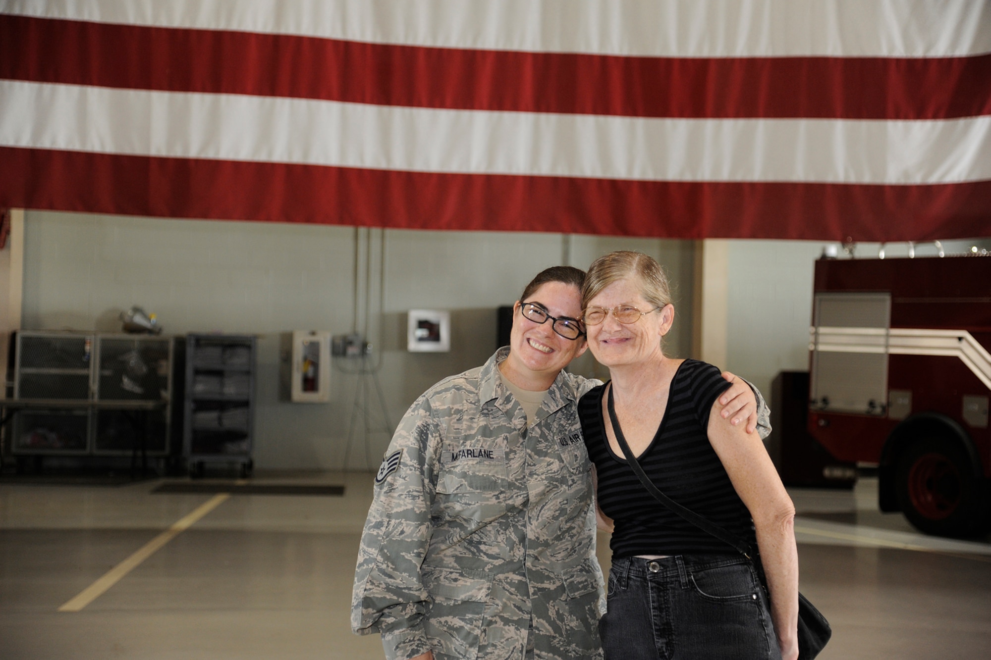U.S. Air Force Staff Sgt. Laura R. McFarlane, 17th Training Wing Public Affairs photojournalist craftsman, poses with Susan G. McFarlane, at the Louis F. Garland Department of Defense Fire Academy on Goodfellow Air Force Base, Texas, June 24, 2105. Staff Sgt. McFarlane reenlisted after serving 13 years. (U.S. Air Force photo by Tech. Sgt. Austin Knox/Released)