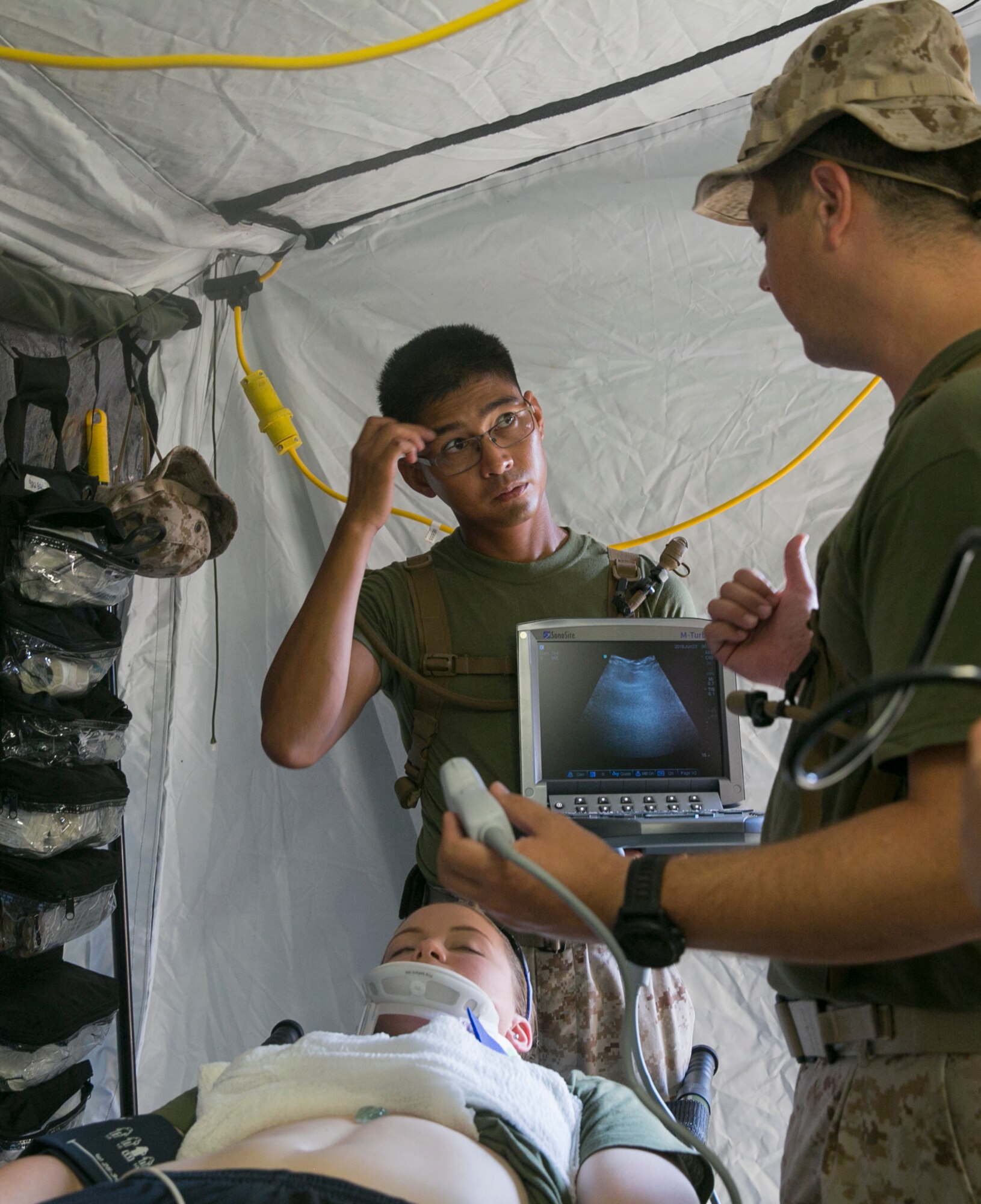 Lieutenant Junior grade Jason Bond, a physician assistant with Combat Logistics Battalion, currently augmented to 2nd Medical Battalion, 2nd Marine Logistics Group, discusses ultrasound techniques with Petty Officer 2nd Class Ryan Demegillo, a corpsman with the battalion, during shock trauma platoon training, June 23, 2015, aboard Camp Lejeune, N.C., as part of a field exercise. For certain injuries, medical personnel need to look at ultrasound images to see if a patient has any internal bleeding. The medical exercise is being conducted in order to familiarize the medical personnel with their capabilities and equipment in an austere environment. (U.S. Marine Corps photo by Cpl. Elizabeth Case/Released)