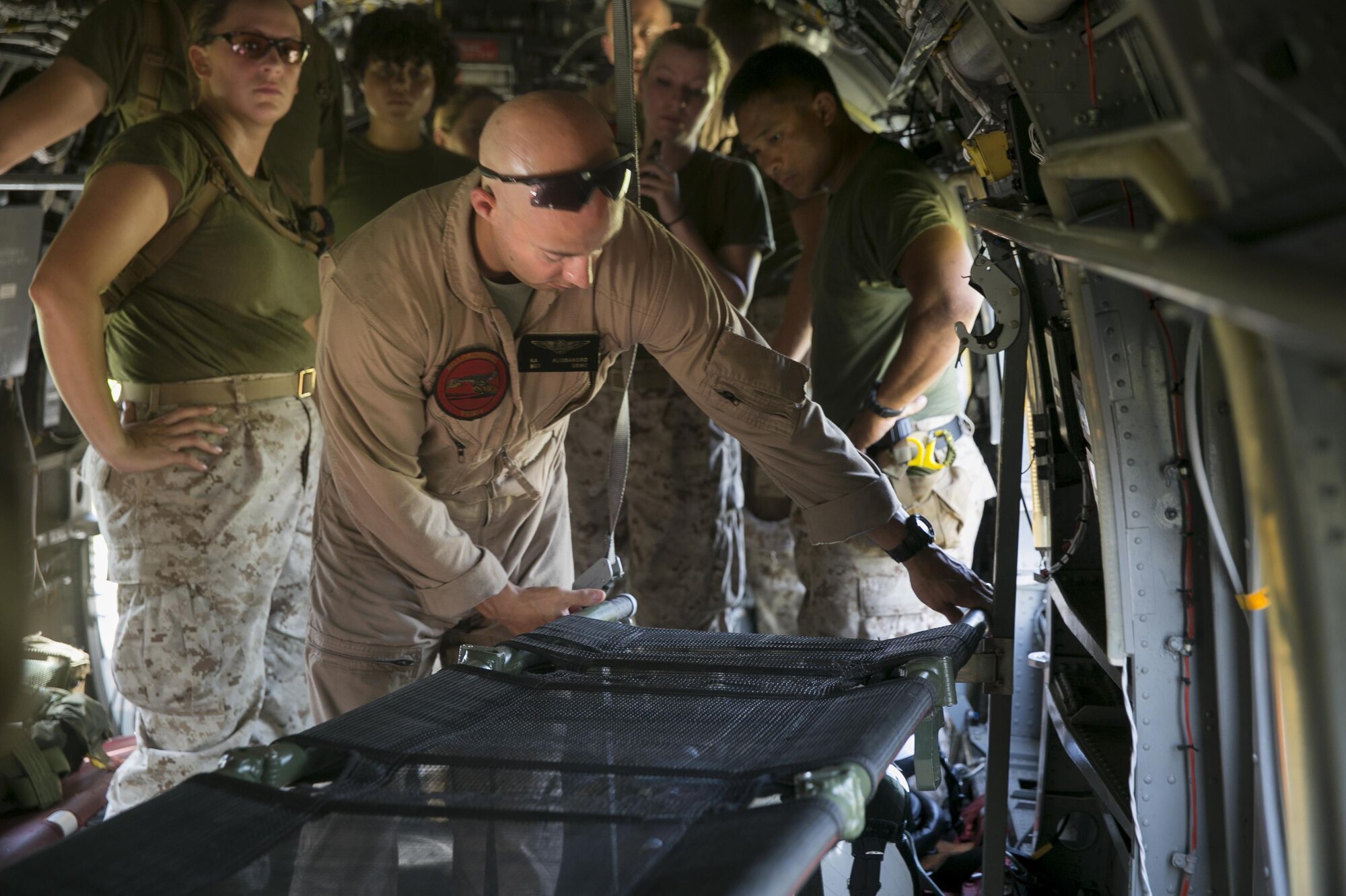 Sgt. Kyle Alessandro, a crew chief and rescue swimmer with Marine Transport Squadron 1, Marine Corps Air Station Cherry Point, demonstrates how to secure a litter for transporting patients in a HH-46E Sea Knight aircraft, June 23, 2015, aboard Camp Lejeune, N.C., as part of a medical field exercise being conducted by 2nd Medical Battalion, 2nd Marine Logistics Group. The medical exercise is being conducted in order to familiarize the medical personnel with their capabilities and equipment in an austere environment. (U.S. Marine Corps photo by Cpl. Elizabeth Case/Released)