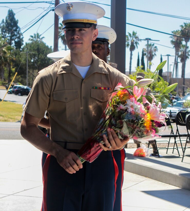 Marines present flowers to the wife of Col. James H. Herrera, the outgoing commanding officer of I Marine Expeditionary Force Headquarters Group, aboard Marine Corps Base Camp Pendleton, Calif., June 25, 2015. Herrera relinquished command of I MHG to Col. Roberta L. Shea. (Photo by LCpl. Danielle Rodrigues/Released)