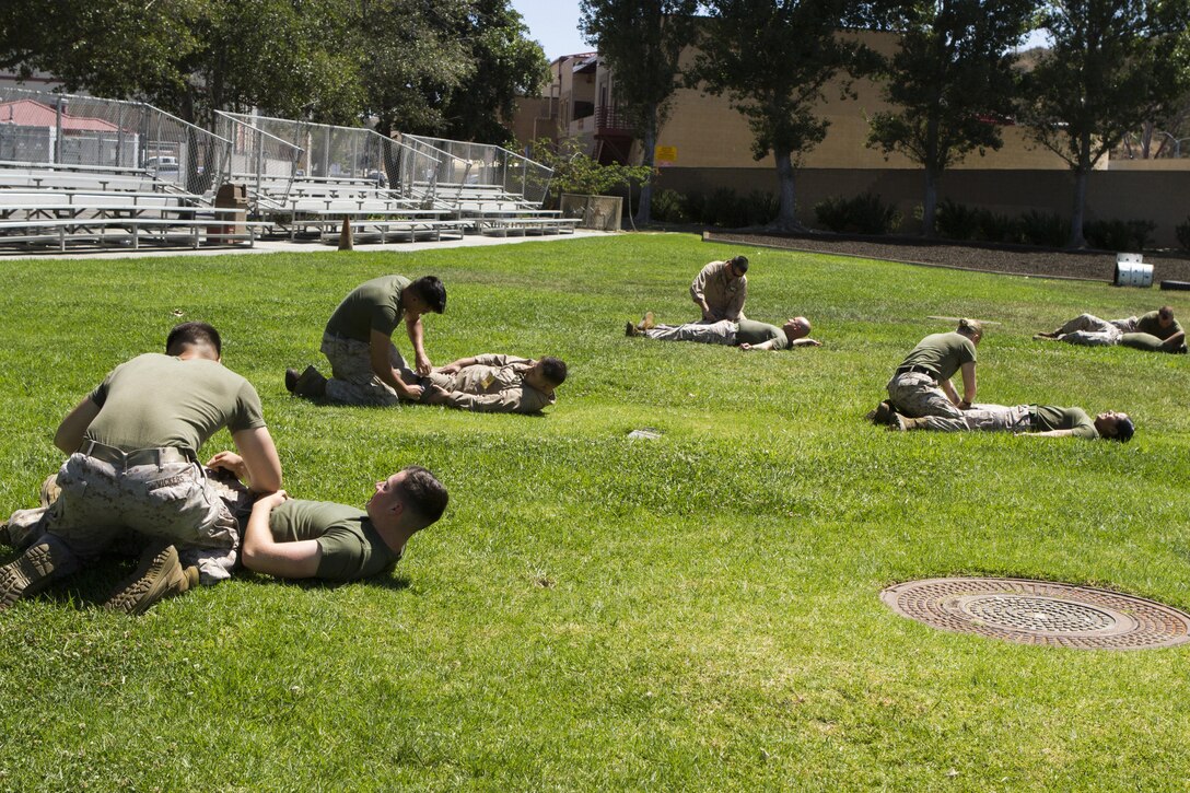 Marines with the 3rd Marine Aircraft Wing practice applying tourniquets to each other during a combined Tactical Combat Casualty Care and Combat Lifesavers Course aboard Marine Corps Air Station Camp Pendleton, California, June 15. Throughout the course, the Marines used various life-saving techniques to accomplish instructor-driven scenarios.