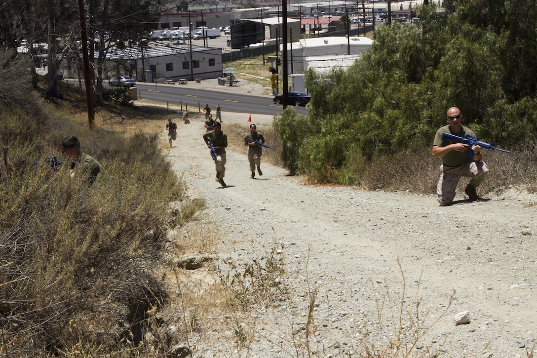 Marines with 3rd Marine Aircraft Wing rush to locate and secure injured personnel during a combined Tactical Combat Casualty Care and Combat Lifesavers Course aboard Marine Corps Air Station Camp Pendleton, California, June 16. In this scenario, enemy combatants shot down a helicopter, and the Marines had to secure an area for medical evacuations after finding the injured crewmembers.