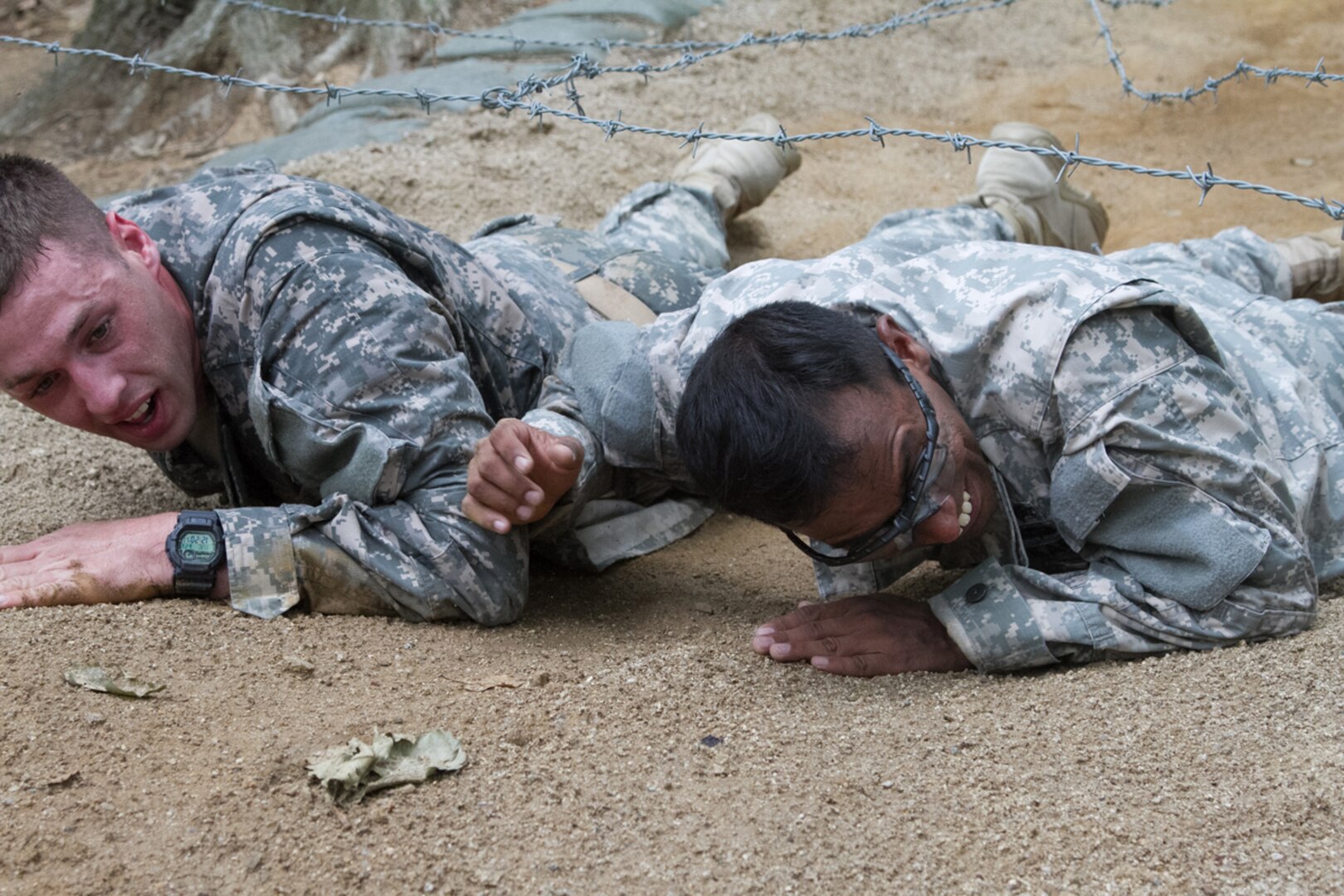 CAMP HUMPHREYS, South Korea (June 23, 2015) - Sgt. Balamurali Devarajan, a flight medic with the Company C, 3rd General Support Aviation Battalion, 2nd Combat Aviation Brigade, and Sgt. Scott Lackey, an emergency care noncommissioned officer with the 602nd Aviation Support Battalion, 2nd CAB, use teamwork to crawl under low barbed wire during the 2nd Infantry Division Best Medic Competition at an obstacle course.  Devarajan and Lackey were part of a two-Soldier team hoping for a chance to compete in the 8th U.S. Army Best Medic Competition. The event included day and night land navigation, a written test, and obstacle course, a physical fitness challenge and a buddy run.  