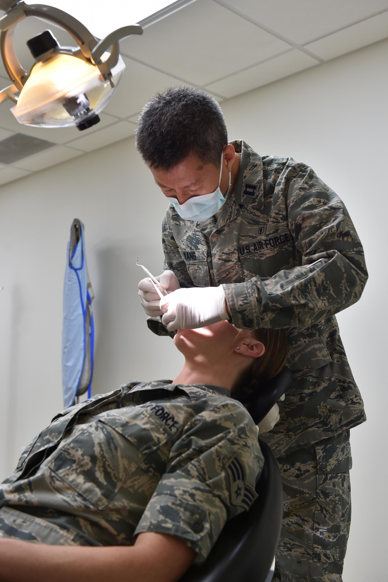 Captain Chris Kang performs a dental examination for Senior Airman Christine Francis here June 6, 2015. Kang is a dental officer with the 910th Medical Squadron and Francis is with the 910th Operations Support Squadron. Dental checks are a critical piece of the pre-deployment process for Airmen. (U.S. Air Force photo/Tech. Sgt. James Brock)