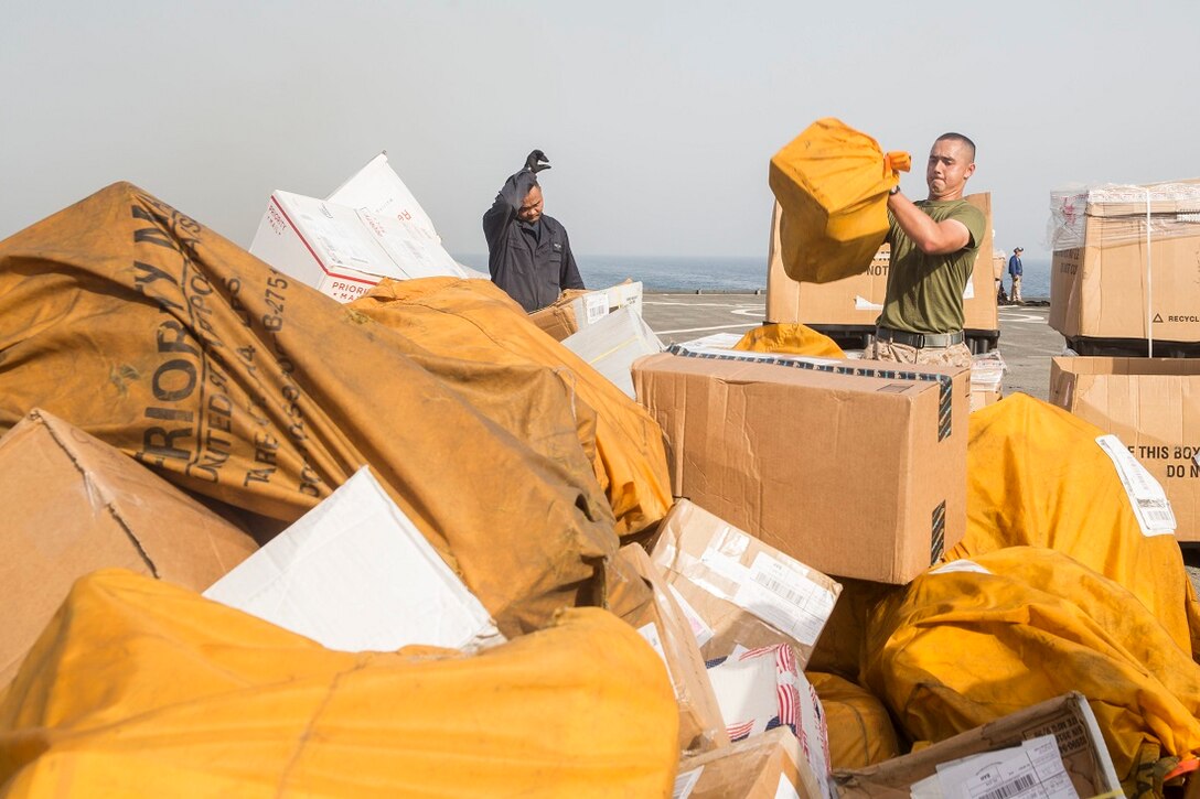 U.S. Marine Lance Cpl. Patrick Usog unloads mail during a replenishment at sea aboard the Whidbey Island-class dock landing ship USS Rushmore (LSD 47). Usog is a mail clerk with Combat Logistics Battalion 15, 15th Marine Expeditionary Unit. Marines and sailors with the 15th MEU, and Essex Amphibious Ready Group worked together to offload food, maintenance parts, and letters from home. The 15th MEU is embarked on the Essex ARG and deployed to maintain regional security in the U.S. 5th Fleet area of operations. (U.S. Marine Corps photo by Sgt. Emmanuel Ramos/Released)