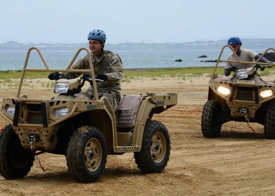 Two Gold Team members from the 320th Special Tactics Squadron Gold Flight, receive all-terrain vehicle qualification training during exercise Gold Thunder 2.0 at Camp Hansen, Japan, June 23, 2015.  It is necessary for members to be able to cover more ground on the quad when securing the area.  Gold Thunder 2.0 is a humanitarian assistance/disaster relief scenario exercise put together to train the combat mission support personnel in land and water navigation, establishing a special tactics operations center and a forward operating logistics hub along with other skills such as all-terrain vehicle qualification training, Krav Maga training and exfiltration capabilities with rotary wing aircraft. (U.S. Air Force photo by Tech. Sgt. Kristine Dreyer)  (U.S. Air Force photo by Tech. Sgt. Kristine Dreyer, 353rd SOG PA/Released)