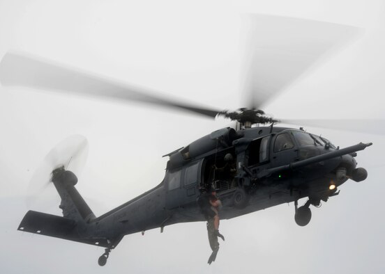 A 320th Special Tactics Squadron pararescueman hoists a Gold Team member out of the water into a Kadena-based HH-60 from the 33rd Rescue Squadron during Gold Thunder 2.0 held at Camp Hansen July 24, 2015.  The exercise scenario ended with a sanitation and evacuation of the forward operating location by water via rotary wing aircraft.  Gold Thunder 2.0 is a humanitarian assistance disaster/relief scenario exercise put together to train the combat mission support personnel in land and water navigation, establishing a special tactics operations center and a forward operating logistics hub along with other skills such as all-terrain vehicle qualification training, Krav Maga training and exfiltration capabilities with rotary wing aircraft. (U.S. Air Force photo by Tech. Sgt. Kristine Dreyer)    