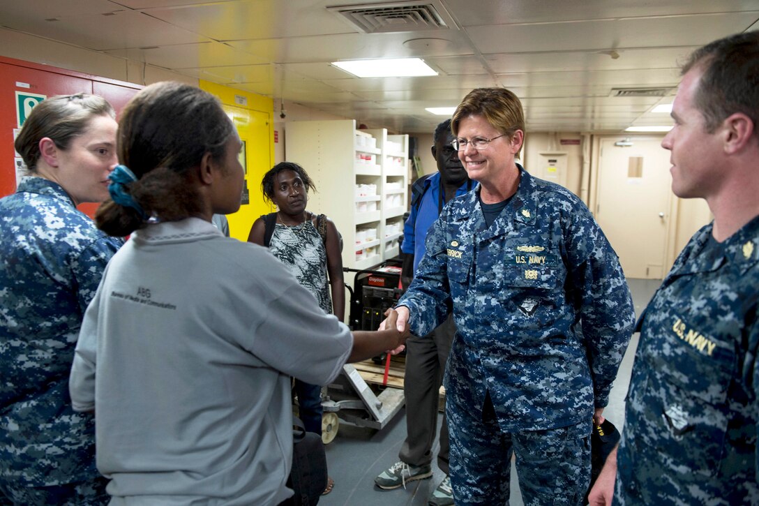 U.S. Navy Capt. Melanie Merrick, commanding officer of Medical Treatment Facility USNS Mercy, greets media members from Papua New Guinea for a tour of the ship during Pacific Partnership 2015 in Papua New Guinea, June 27, 2015.