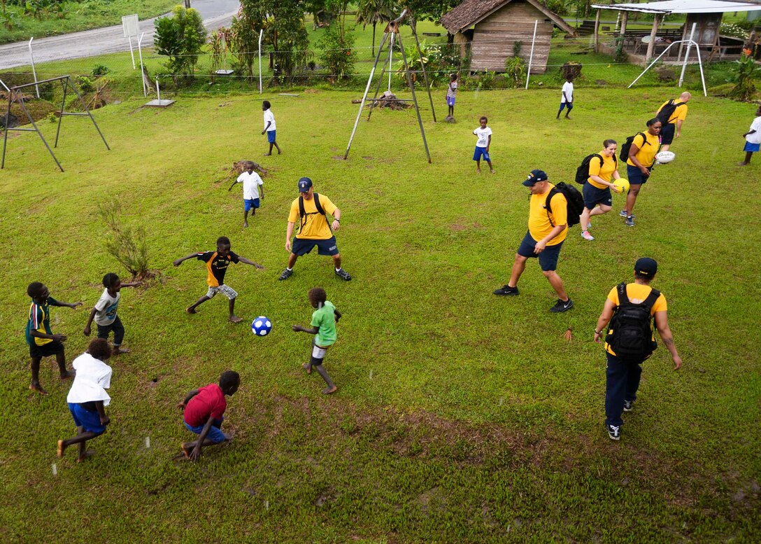 U.S. Navy sailors play soccer with children from the Kobuan School ...