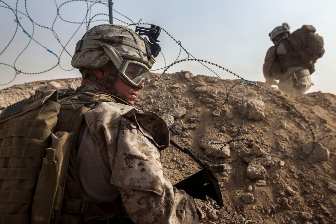 U.S. Marine Corps Sgt. Sean Turner signals members of the security patrol to cross an open space during the unit’s Mission Readiness Exercise in Southwest Asia, June 24, 2015. Turner is assigned to India Company, 3rd Battalion, 7th Marine Regiment, Special Purpose Marine Air-Ground Task Force-Crisis Response, Central Command.
