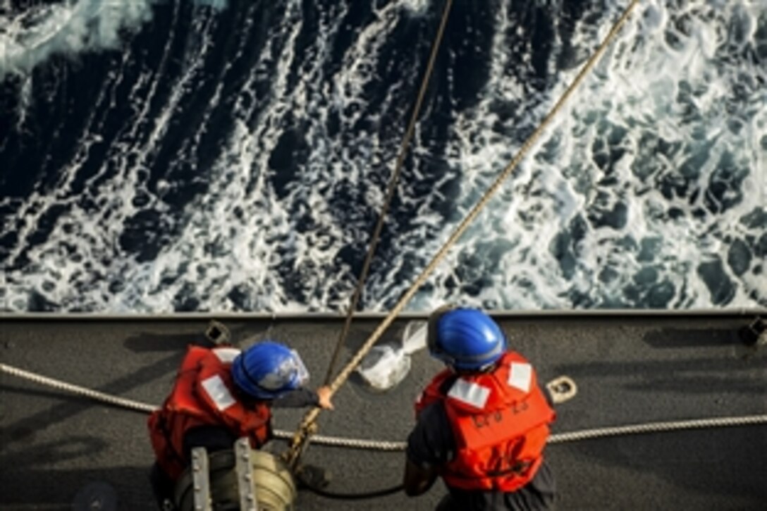 U.S. sailors reel in a fuel hose line aboard the amphibious transport dock ship USS Anchorage during replenishment at sea with the Military Sealift Command dry cargo and ammunition ship USNS Carl Brashear in the Gulf of Aden, June 28, 2015. 
