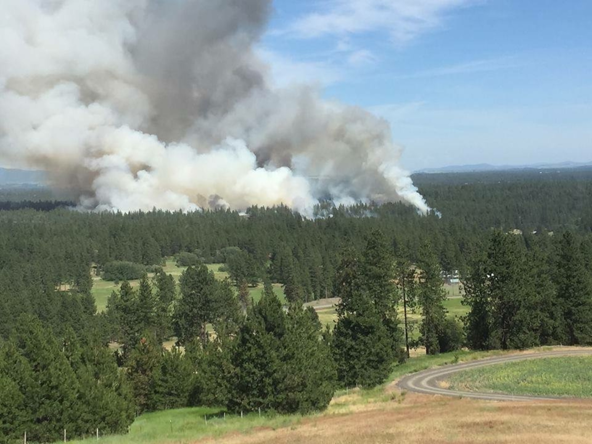 The Fish Lake Fire near Cheney, Wash., June 17, 2015, is seen from a nearby hill. Firefighters from Fairchild Air Force Base, Wash., assisted other area firefighters saving homes and their inhabitants from the 145-acre brush fire. More than 100,000 wildfires burn an average of four to five million acres of land nationwide each year and have burned up to nine million acres in recent years. There are three conditions required for a wildfire to burn including fuel, oxygen and a heat source. Lightning, hot winds, fireworks and even the sun can all provide sufficient heat to spark a fire. (U.S. Air Force photo)