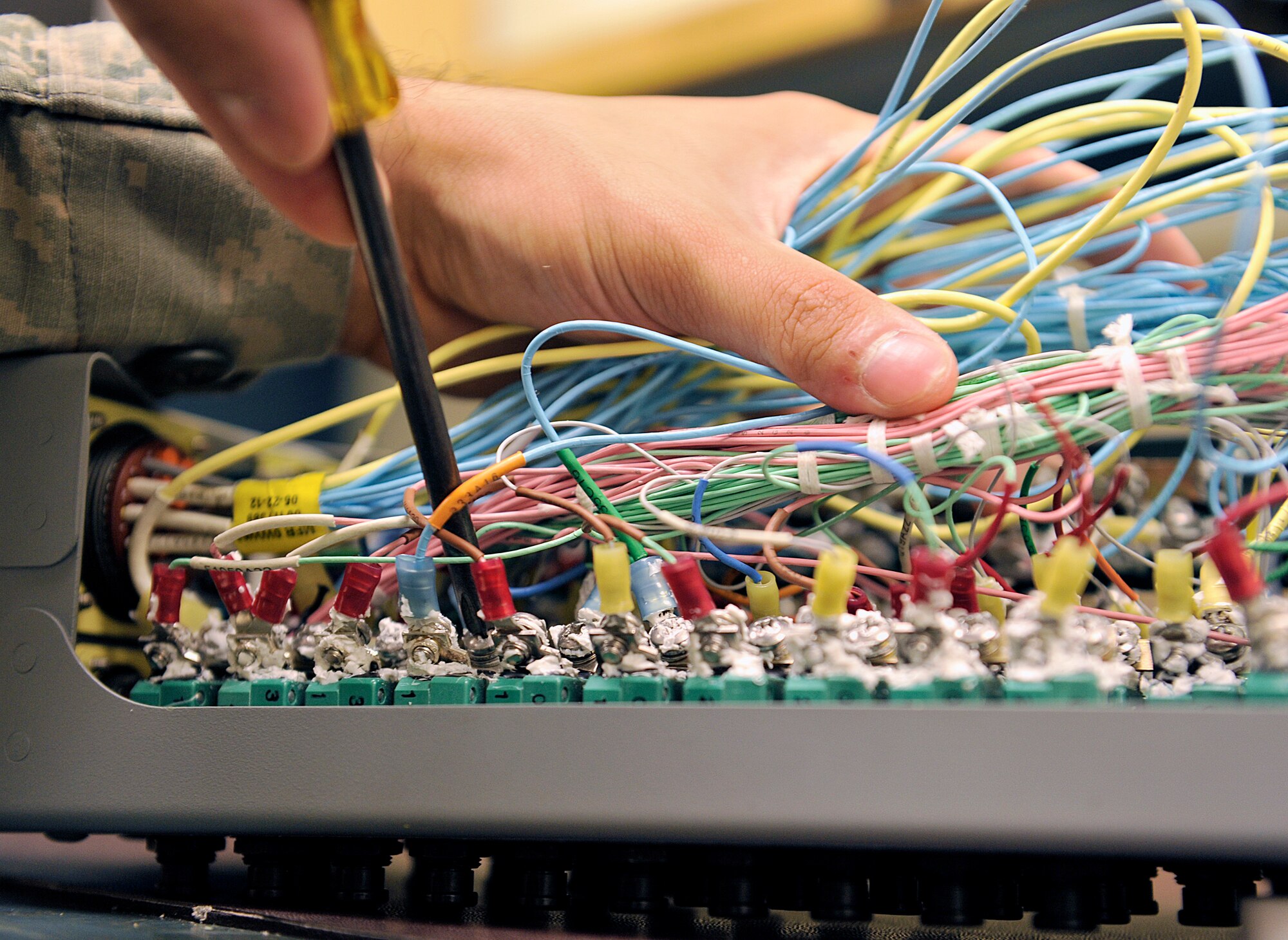U.S. Air Force Airman 1st Class Luis Andrade, 18th Component Maintenance Squadron electrical and environmental journeyman, unscrews an F-15C Eagle essential bus circuit breaker panel on Kadena Air Base, Japan, June 25, 2015. The panel interrupts the flow of electricity to prevent a system or component failure downstream of the circuit breaker, ensuring the F-15s' capability to provide for the common defense of Japan. (U.S. Air Force photo by Naoto Anazawa)
