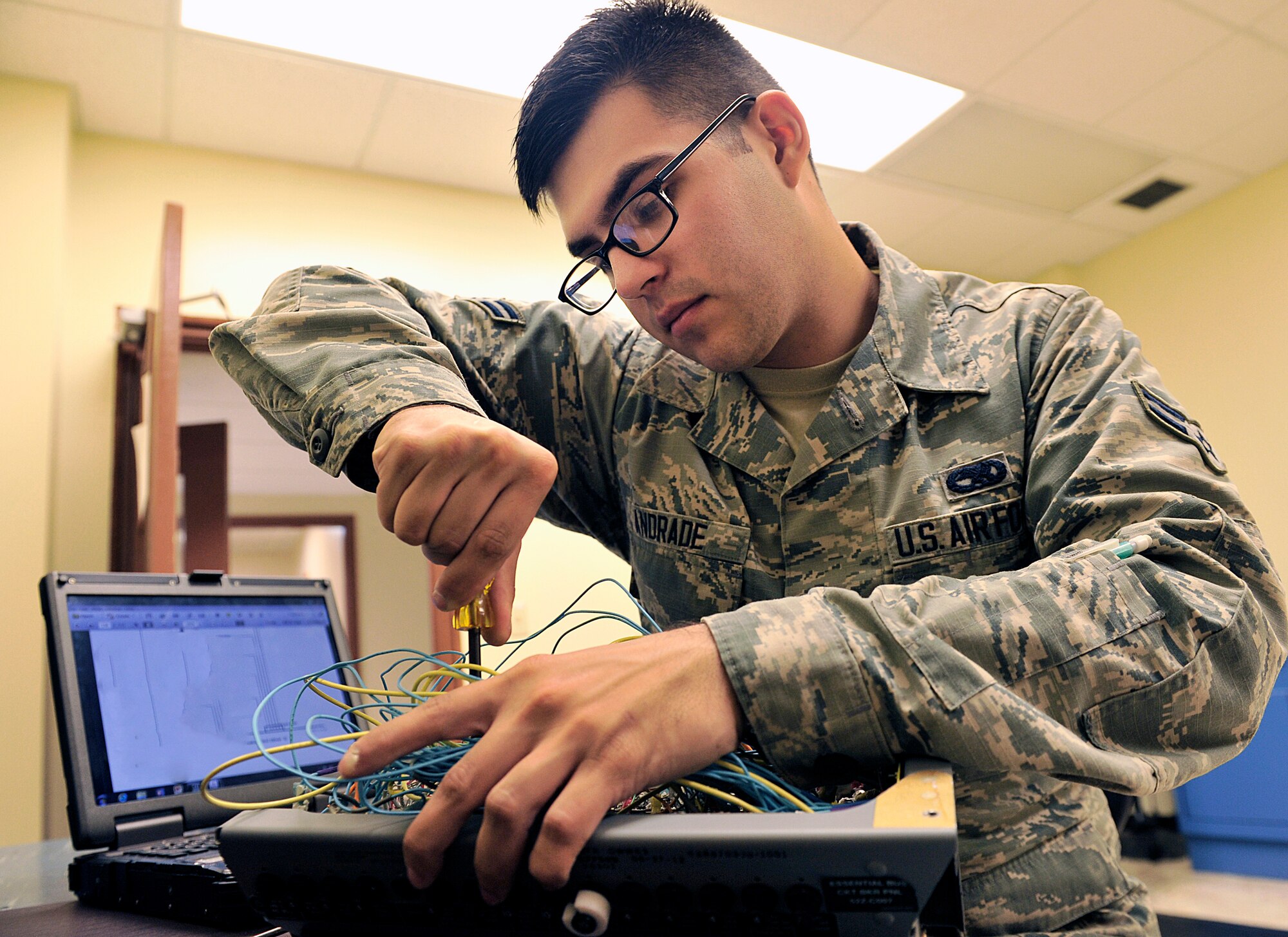 U.S. Air Force Airman 1st Class Luis Andrade, 18th Component Maintenance Squadron electrical and environmental journeyman, unscrews an F-15C Eagle essential bus circuit breaker panel on Kadena Air Base, Japan, June 25, 2015. The breaker's purpose is to prevent the systems from failing and to reduce the risk of electrical fire by shutting off power to failed systems. (U.S. Air Force photo by Naoto Anazawa)