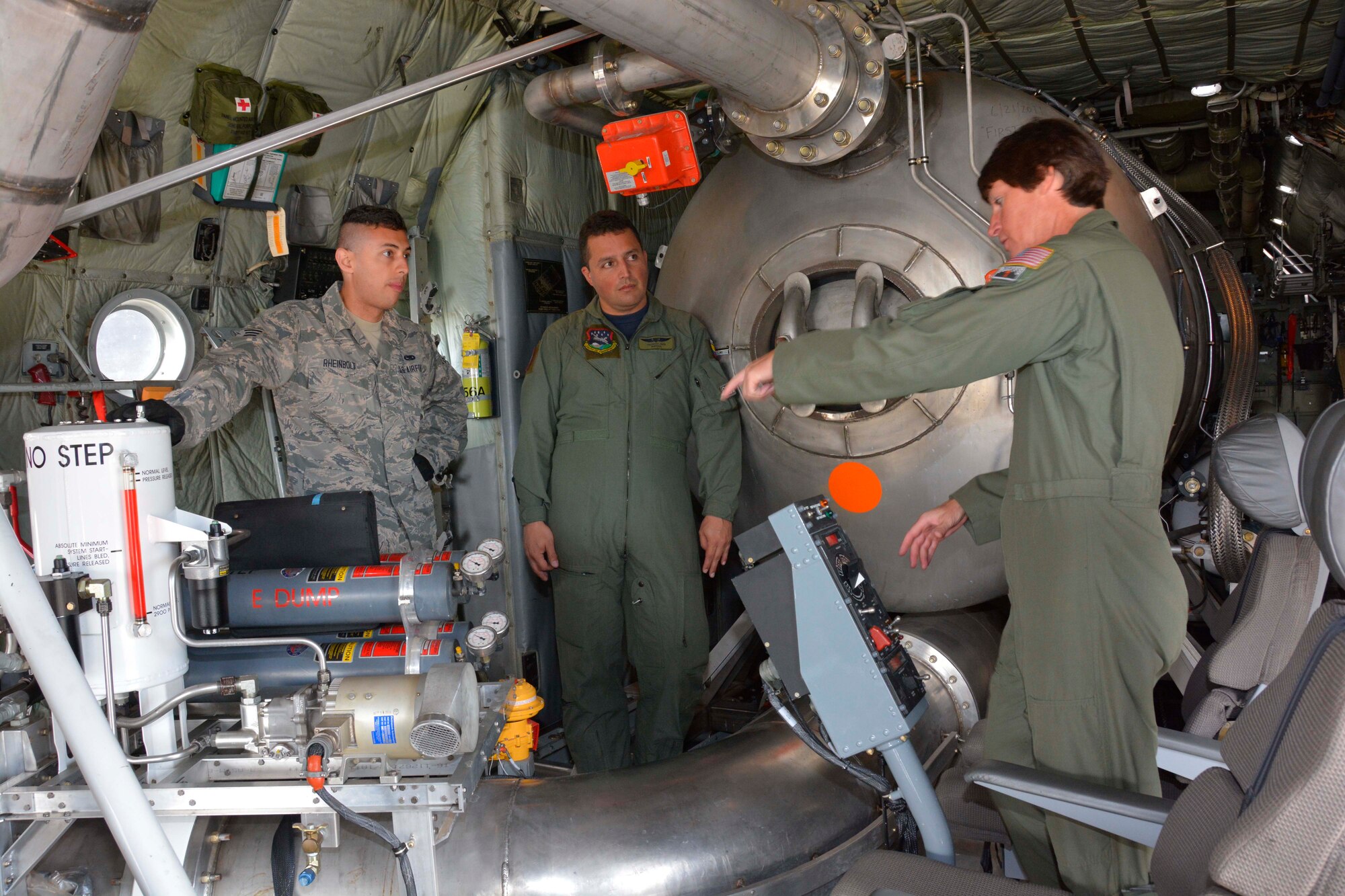 U.S. Air Force Master Sgt. Pennie Brawley, loadmaster for the 145th Airlift Wing, explains while Senior Airman Winston Rheinbolt, crew chief for the 145th Maintenance Squadron, translates in Spanish, the procedures used when operating a Modular Airborne Firefighting System II (MAFFS II) to visiting aircrew member from Colombian Fuerza Aerea C-130 community. Senior aircrew instructors from the 81st, Escuadrón de Transporte, Bogota were given a first-hand look at the unit during the 2015 annual classroom certification and re-certification training, held April 29 thru May 3, 2015 at the North Carolina Air National Guard Base, Charlotte Douglas International Airport. (U.S. Air National Guard photo by Master Sgt. Patricia F. Moran, 145th Public Affairs/Released)